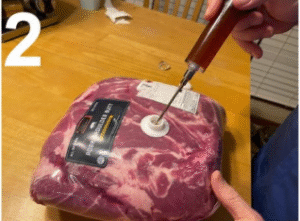 pork shoulder roast with marinade needle inserted