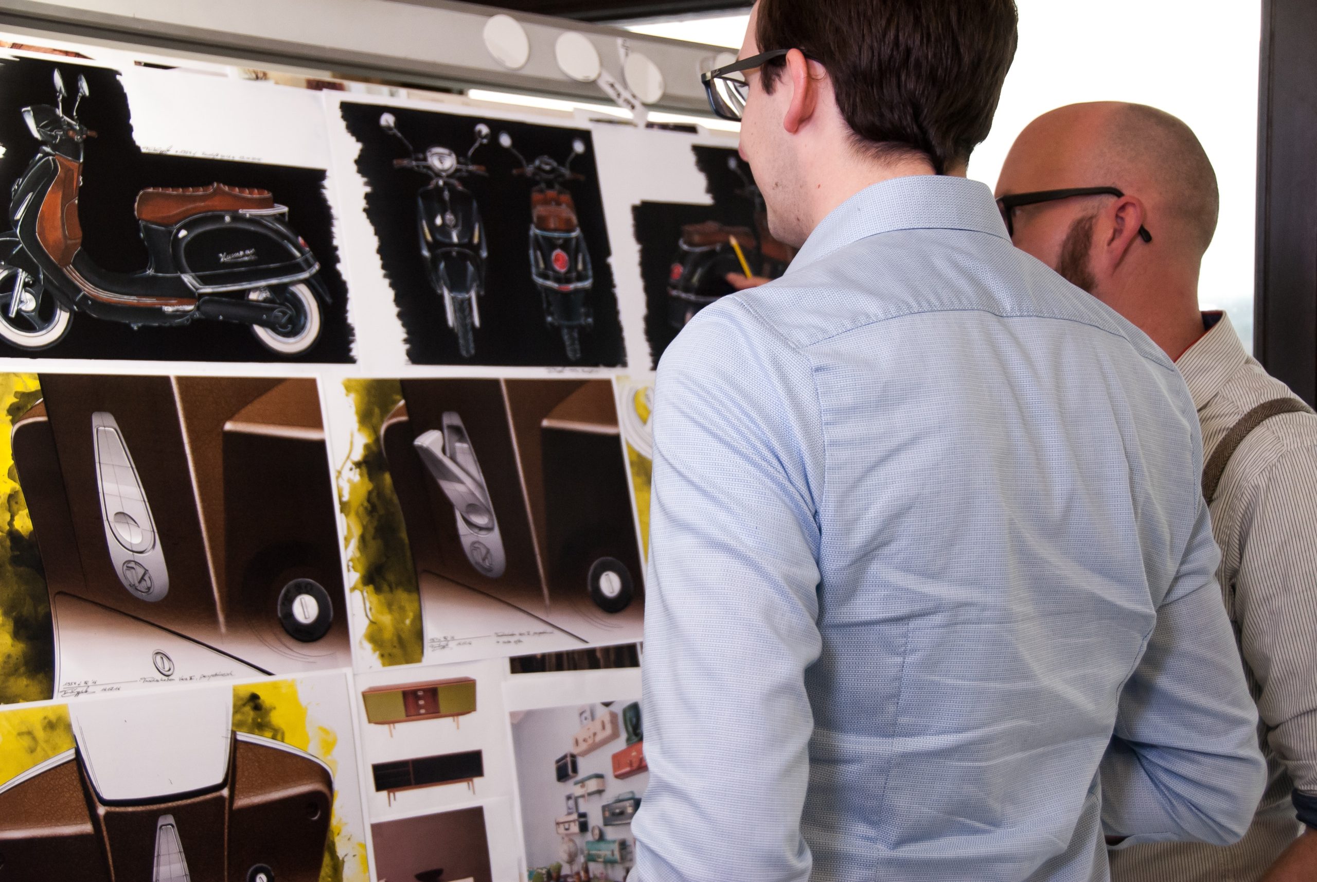 Two men reviewing plans for a motorcycle.